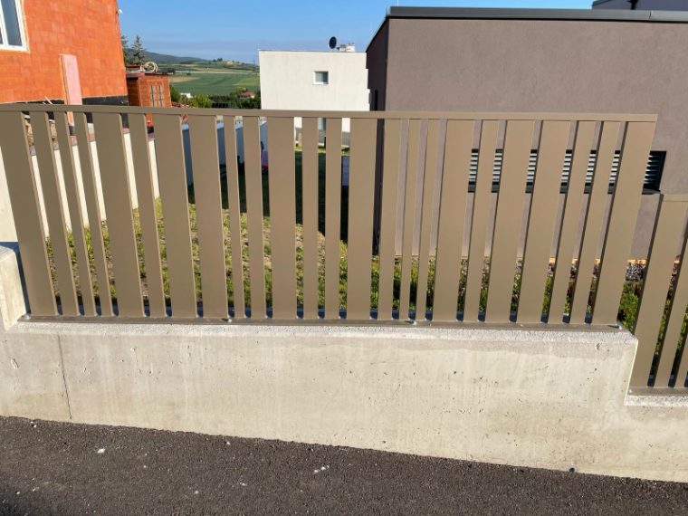 Sichtschutz aus schräg gestellten Metalllamellen auf einer Betonmauer