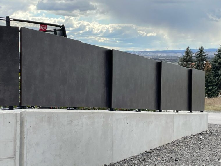 Dunkle Sichtschutzwand auf einer Betonmauer