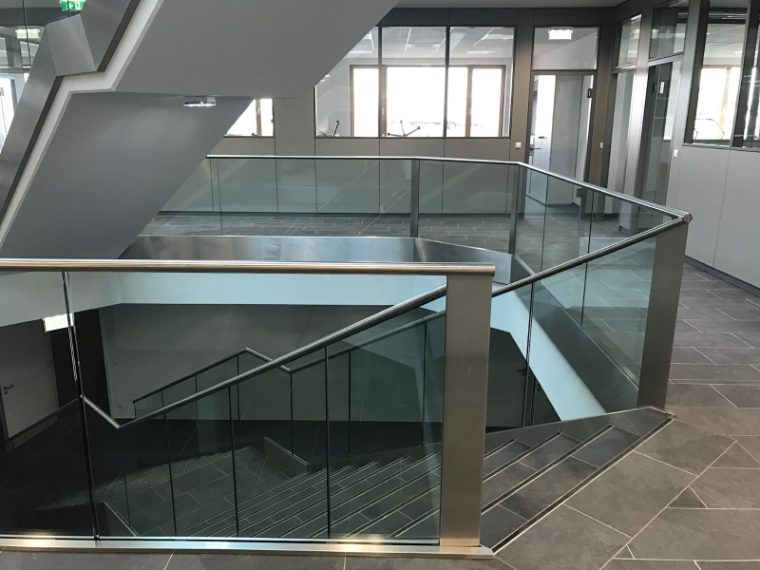 Innenstiege mit Brüstung aus Glas und Stahl