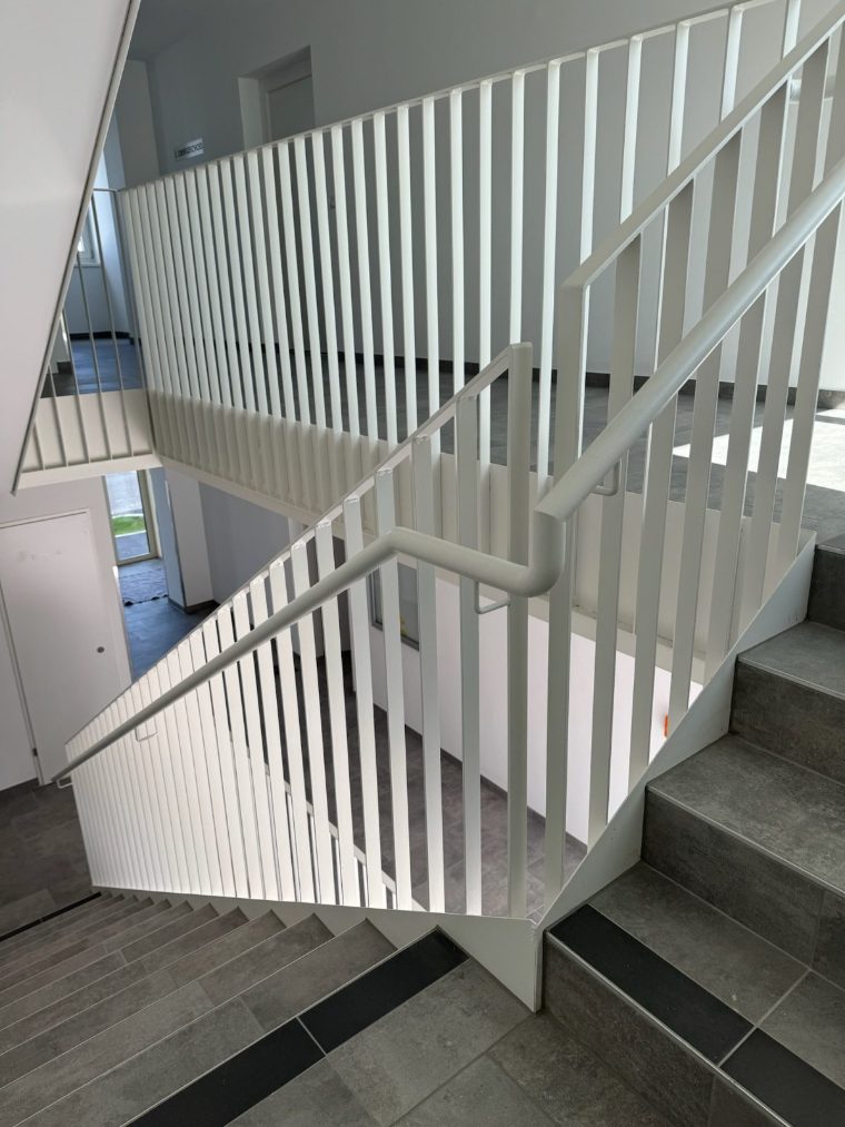 Stiege mit weiß beschichtetem Stahlgeländer