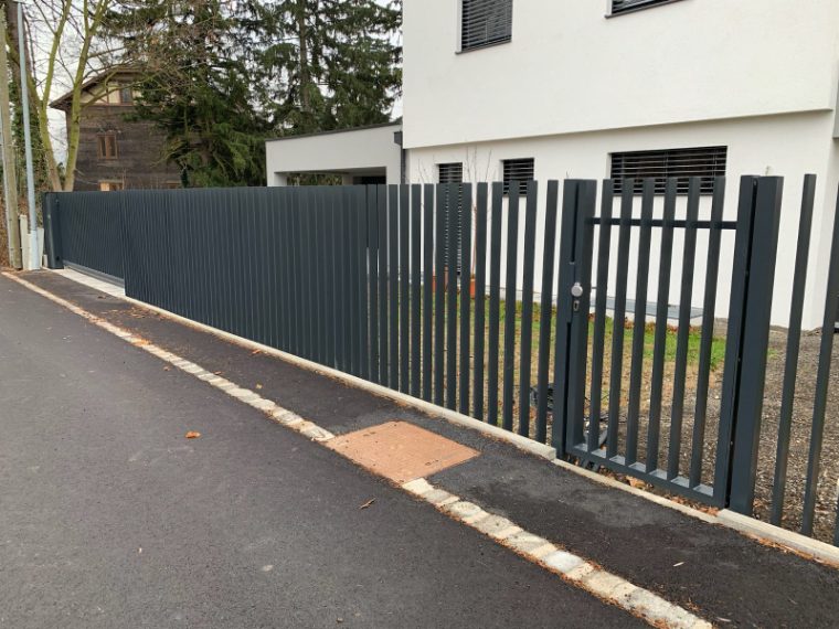 Einfahrt mit Zaunanlage und Sichtschutzelementen
